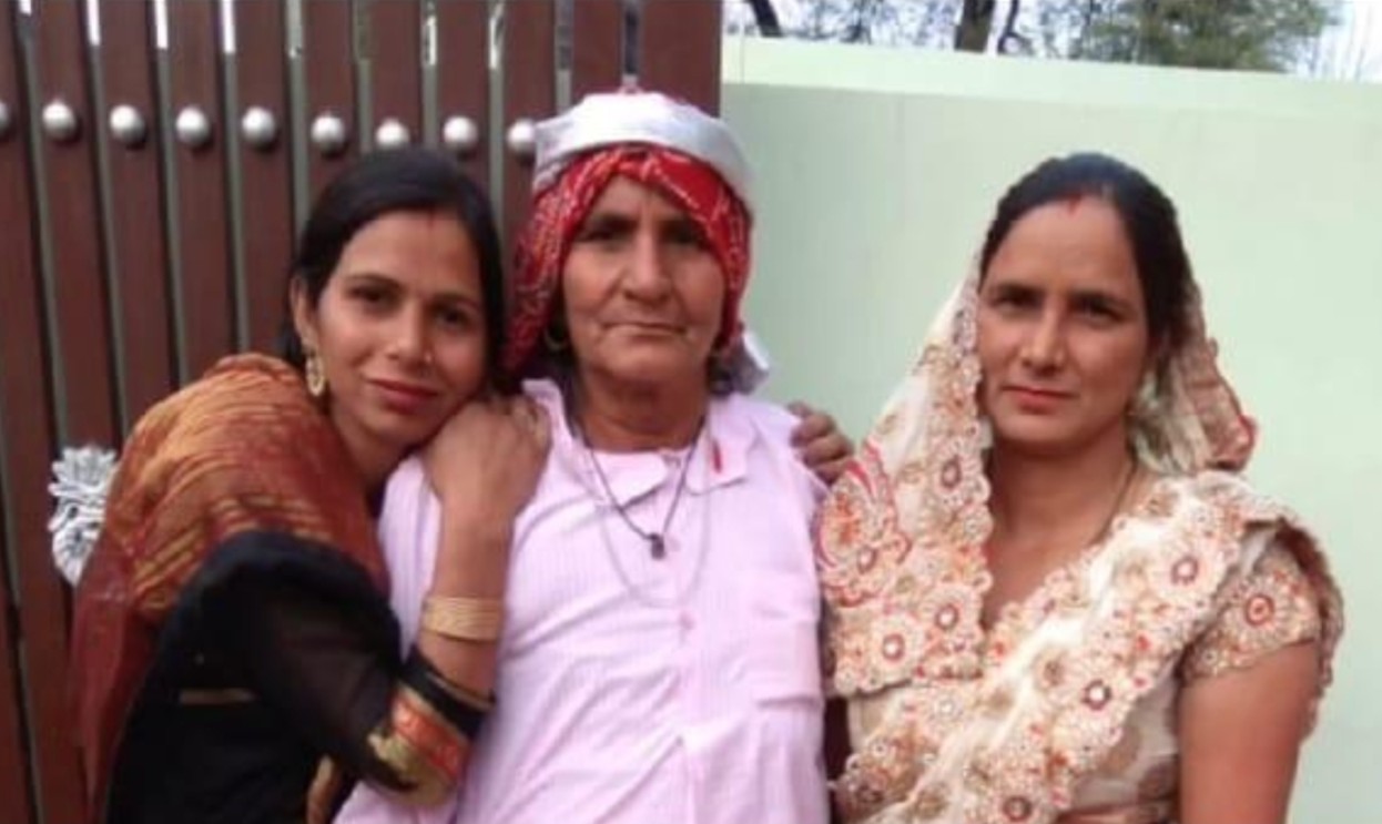 Dadi standing outdoors with two daughters